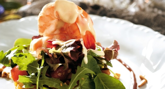 Ensalada de langostinos y frutos secos sobre fondo de chutney de piña
