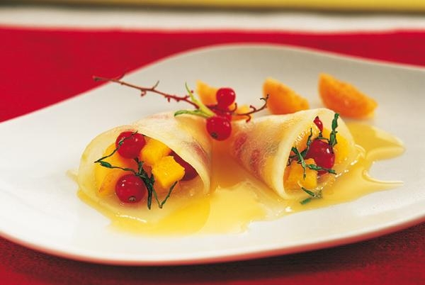 Raviolis de melón rellenos de mango, menta y grosellas en salsa de naranja
